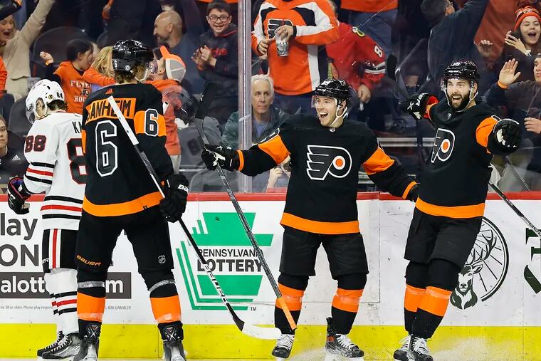 Flyers right wing Cam Atkinson (center) celebrates his game winning third period goal with teammates center Derick Brassard and defenseman Travis Sanheim past Chicago Blackhawks right wing Patrick Kane on Saturday, March 5, 2022 in Philadelphia.  The Flyers beat the Chicago Blackhawks 4-3.