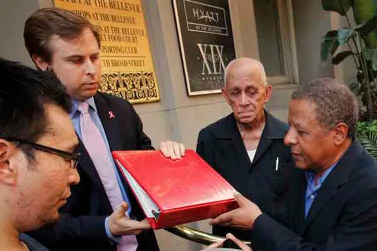 Joshua Novotney, Director of Governor's Southeast Regional Office receives a binder full of qualified latinos available to work with Governor. Presenting the binder id Pedro Rodriguez, community activist. Latino organizations gather along S. Broad St. outside the Philadelphia offices of Pennsylvania Governor Tom Corbett on Friday afternoon May 31, 2013. They provided one of his staff members with a binder full of qualified latino residents of the state. ( ALEJANDRO A. ALVAREZ / STAFF PHOTOGRAPHER )