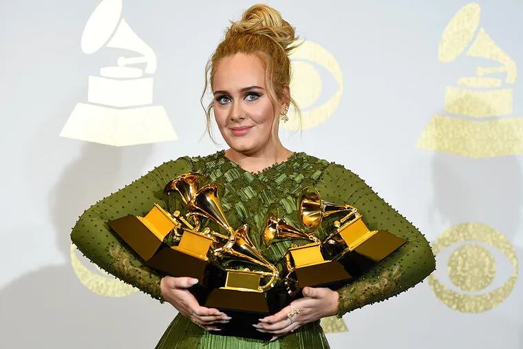 Adele poses in the press room with the awards for album of the year for "25", song of the year for "Hello", record of the year for "Hello", best pop solo performance for "Hello", and best pop vocal album for "25" at the 59th annual Grammy Awards at the Staples Center on Sunday, Feb. 12, 2017, in Los Angeles.
