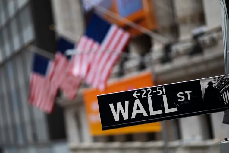 File photo shows a Wall Street sign in front of the New York Stock Exchange. Last week, the Dow industrial average plunged 3,583 points, as investors worried about the potential economic fallout as coronavirus infections spread around the globe.