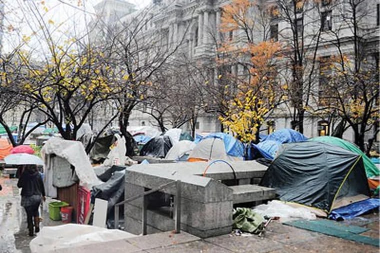Going nowhere, from the looks of it, the Occupy Philly encampment was buttoned up in the rain yesterday. (David Maialetti / Staff Photographer)