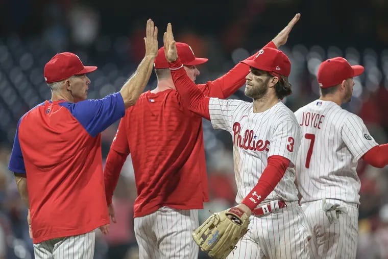 Phillies Bryce Harper high fives manager Joe Girardi after beating the Orioles 4-3 at Citizens Bank Park in Philadelphia, Wednesday, September 22, 2021