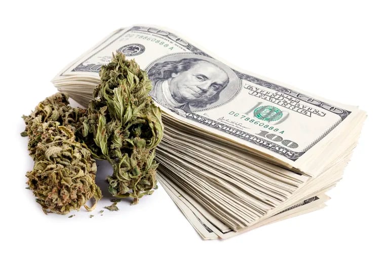 Marijuana flower and a large stack of $100 notes.