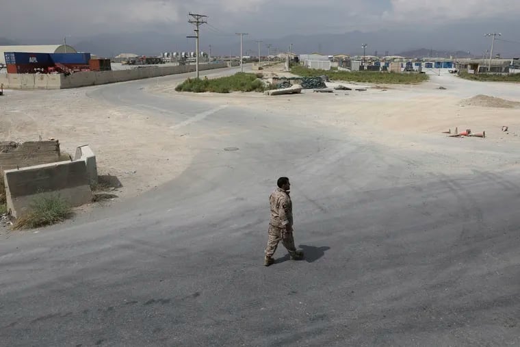 A member of the Afghan security forces walks in the sprawling Bagram air base after the American military departed, in Parwan province north of Kabul, Afghanistan, Monday, July 5, 2021. The U.S. left Afghanistan's Bagram Airfield after nearly 20 years, winding up its "forever war," in the night, without notifying the new Afghan commander until more than two hours after they slipped away.