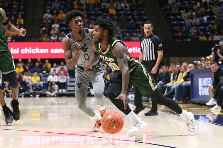 UAB guard Jordan Walker (10) is defended by West Virginia guard Kedrian Johnson (0) during the first half of an NCAA college basketball game in Morgantown, W.Va., Saturday, Dec. 10, 2022.