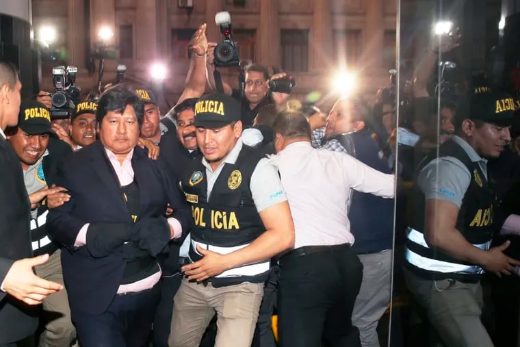 In this photo provided by Peru's Justice Palace press office, Peru's Football Federation President Edwin Oviedo is lead to jail in handcuffs in Lima, Peru, Thursday, Dec. 6, 2018. Oviedo, who was arrested a few months after leading his country back to the World Cup for the first time in 36 years, will be held initially for 15 days as prosecutors investigate his alleged connections to a criminal network that paid for several judges to attend the World Cup in Russia. (Francisco Medina/Peru's Justice Palace via AP)