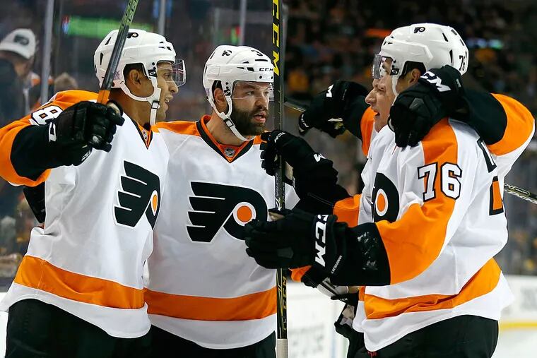 Philadelphia Flyers' Pierre-Edouard Bellemare (78) celebrates his goal with teammates Radko Gudas (3) and Chris VandeVelde (76) during the first period of an NHL hockey game against the Boston Bruins in Boston, Wednesday, Oct. 21, 2015.