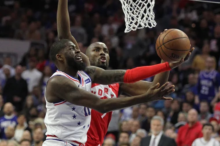 James Ennis, left, of the Sixers goes up for a shot against Serge Ibaka of the Raptors during the 1st half of their NBA Eastern Conference Semifinal Playoff Game at the Wells Fargo Center on May 9, 2019.