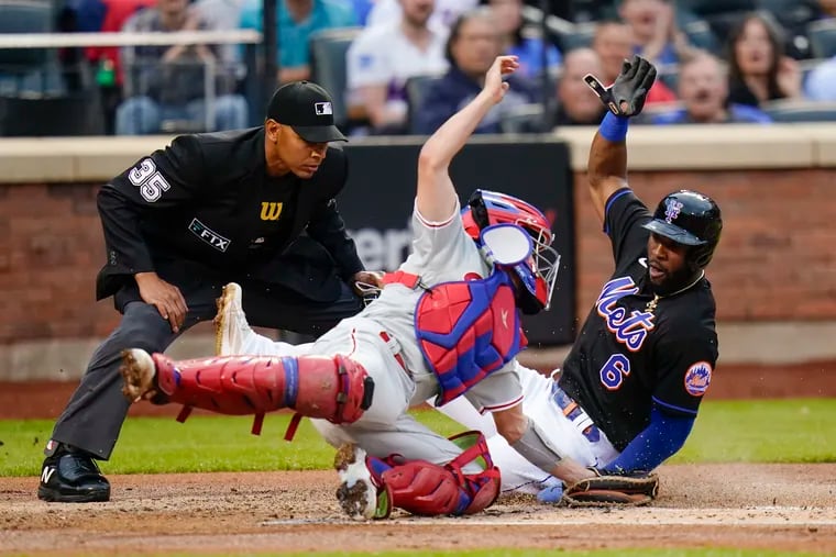 Starling Marte (6) slides past Phillies catcher Garrett Stubbs to score on a sacrifice fly by Eduardo Escobar during the first inning on Friday.