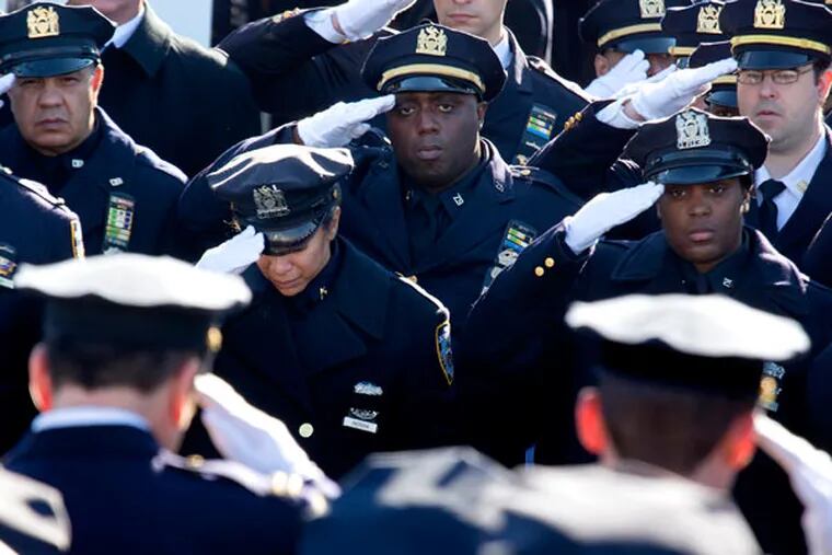 Thousands of police officers and others salute during the funeral of New York City police officer Rafael Ramos outside Christ Tabernacle Church in the Glendale section of Queens on Saturday, Dec. 27, 2014, in New York. (AP Photo/Craig Ruttle)