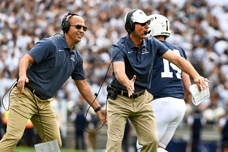Penn State head coach James Franklin and offensive coordinator Mike Yurcich greet players after a score during a 2022 game in State College, Pa.