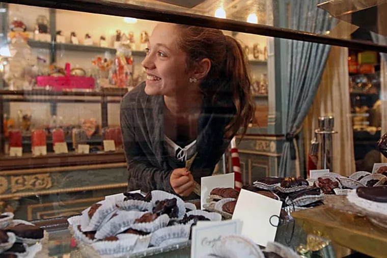 Ali Lucey, 12, of Albany, N.Y., who was visiting with her family for the NCAA hockey championships, peruses the display glass at Shane Confectionery. (Michael Bryant/Staff)