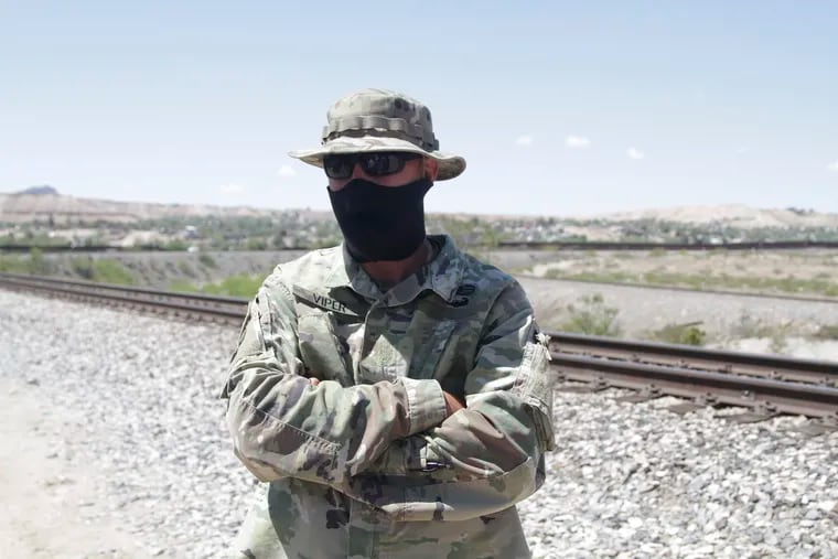 An self-styled Patriot stands a quarter mile from a barrier that marks the U.S.-Mexico border Tuesday, April 23, 2019, in Sunland Park, N.M., hours before being removed from his group's campsite by police. Members of the United Constitutional Patriots gained national attention after filming themselves detaining immigrants who cross the border to the east where the wall ends. (AP Photo/Cedar Attanasio)