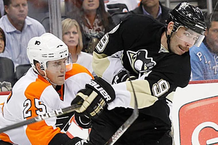 Pittsburgh Penguins' Pascal Dupuis gets tangles up with Philadelphia Flyers' Matt Carle (25) in the second period. (AP Photo/Keith Srakocic)