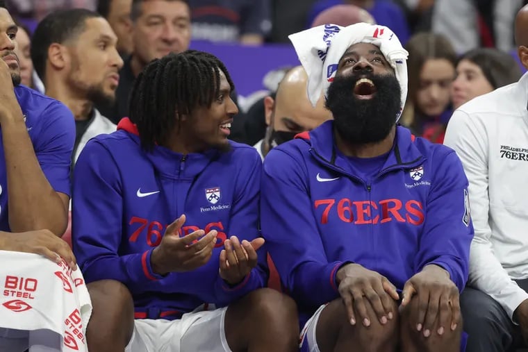 Tyrese Maxey (left) and James Harden of the Sixers share a laugh on the bench late in their preseason game against the Hornets at the Wells Fargo Center on Oct. 12.