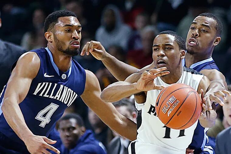 Providence guard Bryce Cotton passes the ball under defensive pressure from Villanova guards Darrun Hilliard II and Tony Chennault during the first half. (Elise Amendola/AP)
