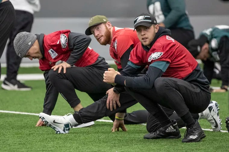 Eagles quarterbacks, Josh McCown, left, Carson Wentz, and Nate Sudfeld, right, stretch prior to the Eagles practice inside the NovaCare Center on Wednesday, December 18, 2019, as they prepare for the game against Dallas