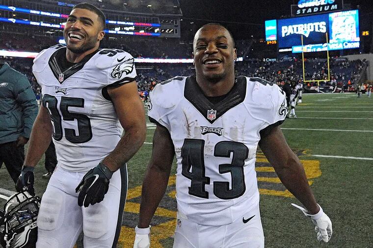 Eagles running back Darren Sproles (right) and linebacker Mychal
Kendricks walk off the field after beating the Patriots.