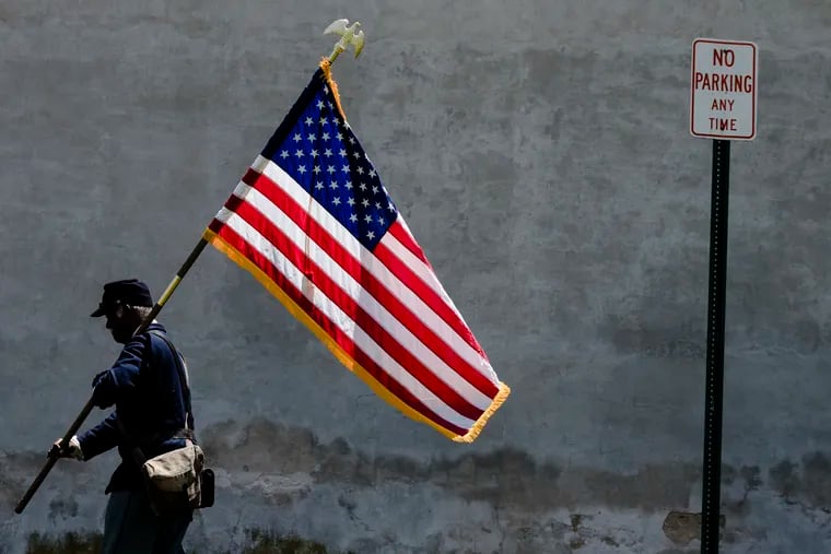 Joseph Becton, a member of the 3rd Regiment Infantry United States Colored Troops Civil War Re-enactors, carries a U.S. flag in Camden in May 2019.
