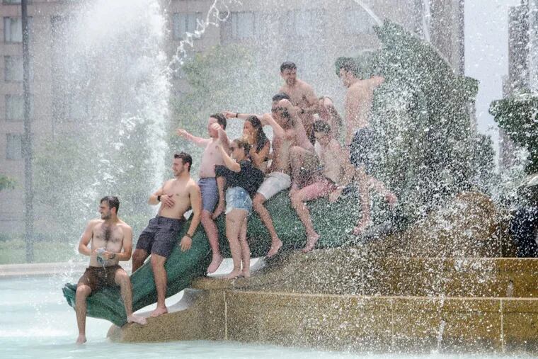 A group of friends gather for photo op while cooling off in Swann Memorial Fountain at Logan Square, July 2017.