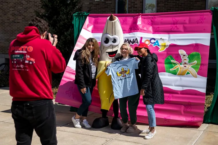 Students take a photo with Loca the banana for Banana Day at West Chester University in West Chester, Pa., on Wednesday, April 20, 2022.