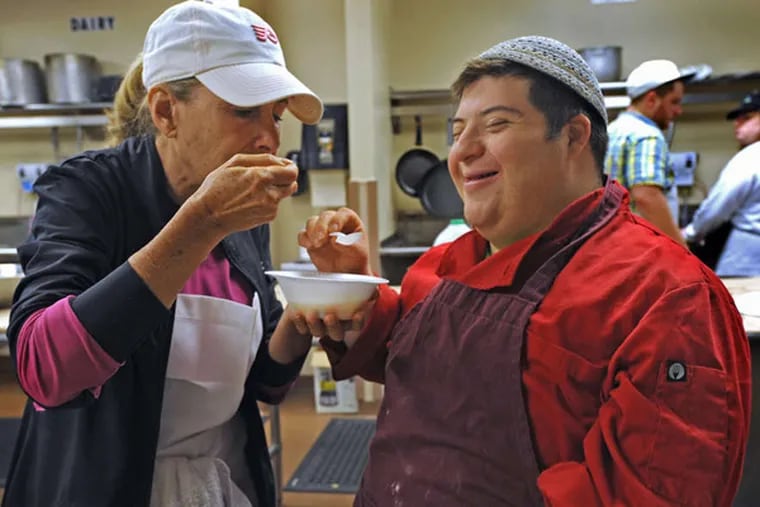 Volunteer Rande Dubrow (left) and student Joey Lerner try a soup prepared by a class in the Soups and Sweets program. The program seeks to give young adults with special needs employable food-service skills. (April Saul / Staff Photographer)