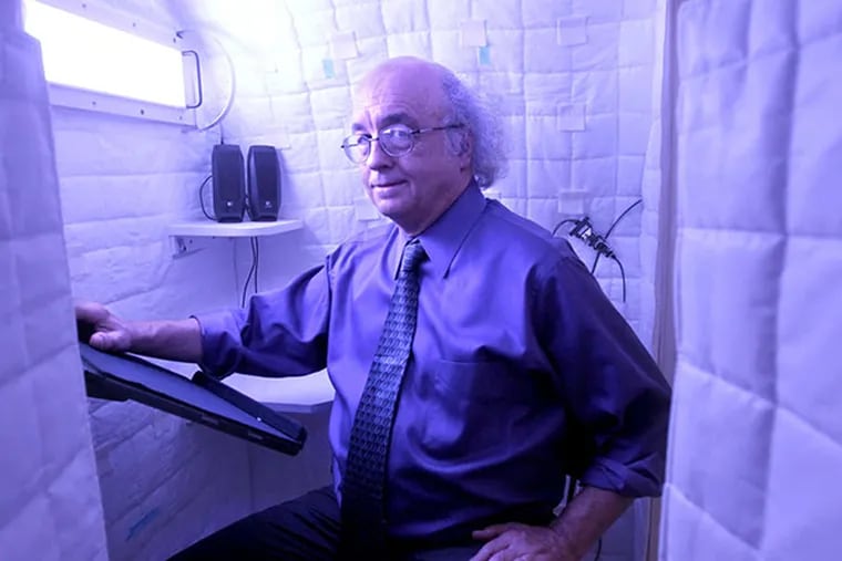 George Brainard shows a light panel in a model of the space station sleeping quarters. The lights have adjustable patterns and wavelengths.