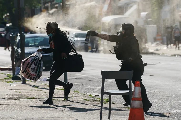 A police officer uses a spray on a person at 52nd and Chestnut streets in West Philadelphia on Sunday, May 31, 2020. On the second day of the George Floyd Protests.