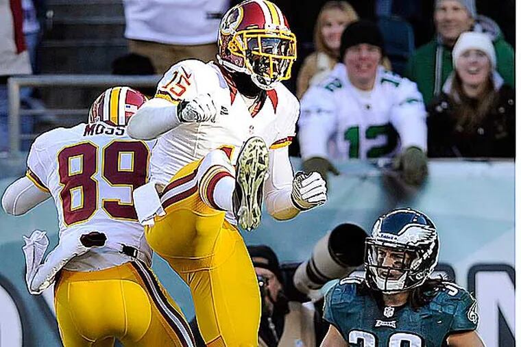Washington Redskins' Santana Moss (left) and Josh Morgan celebrate after Moss' touchdown against Eagles' Colt Anderson (right) during the second half of an NFL football game, Sunday, Dec. 23, 2012, in Philadelphia. (Michael Perez/AP)