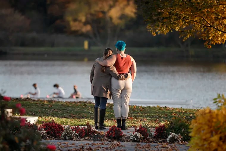 Kelly Lupton (left) of Pilesgrove and Anna Buss of Atco watch the rowers at Cooper River Park in Pennsauken, N.J. on Nov. 9, 2020.  The couple was spending time together celebrating Anna’s 21st birthday. Anna used to row there for Moorestown H.S., the area is important to her so she wanted to share it with Kelly.
