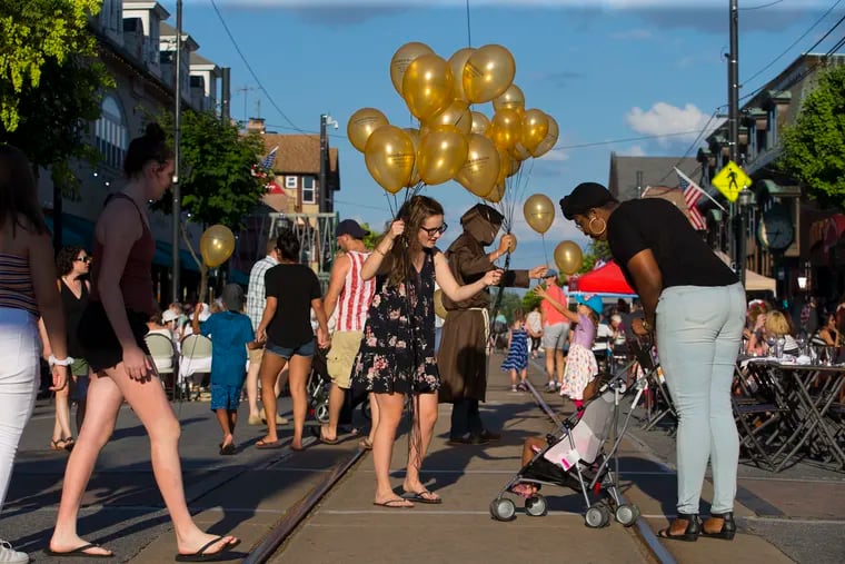 Ally Shearer hands out balloons for Media Eye Works on State Street in Media on July 18, 2018. Every Wednesday during the summer, State Street is closed to traffic for Dining Under the Stars.