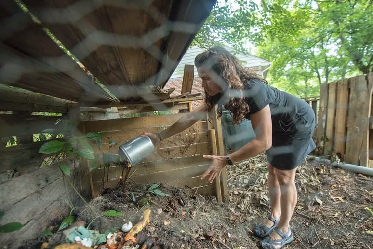 Ines Rodriguez empties her food compost bin on a compost area in her back yard of her home in Swarthmore. Start stirring up those compost bins now.
