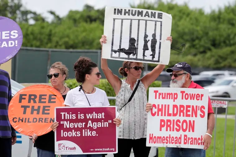 In this July 15, 2019, file photo, protesters hold signs outside of the Homestead Temporary Shelter for Unaccompanied Children while members of Congress tour the facility in Homestead, Fla. The government will be able to hold immigrant children detained at the Mexican border for a longer period of time under a move by the Trump administration, which also has declared it will not provide flu immunizations.