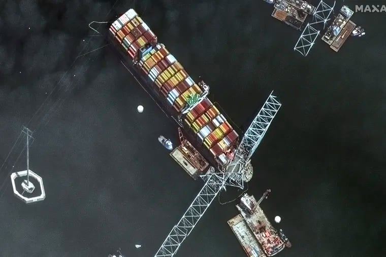 This satellite image provided by Maxar shows the bow of the container ship Dali remains stuck underneath sections of the fallen Francis Scott Key Bridge, while salvage crews and barges with cranes continue removing some of the bridge debris and hundreds of shipping containers still onboard the vessel, in Baltimore, last week.