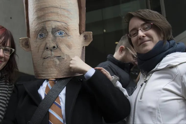 Philadelphia nanny and organizer of Tuesdays with Toomey movement, Alexandra Gunnison (right), with Mimi Salazar, wearing a mask of Sen. Pat Toomey during a 2017 rally. Members of the group say some of their messages to the senator on Facebook get marked as “spam.”