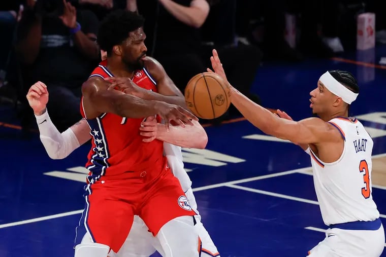 Sixers center Joel Embiid passes the basketball past New York Knicks guard Josh Hart (right) and center Isaiah Hartenstein during the first quarter of Game 1 of their first-round series.
