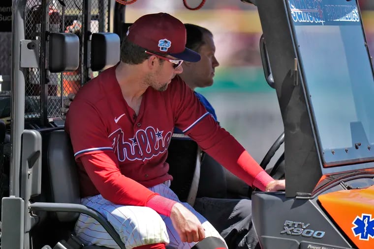 Philadelphia Phillies first baseman Rhys Hoskins is taken off the field after getting injured fielding a ground ball by Detroit Tigers' Austin Meadows during the second inning of a spring training baseball game Thursday in Clearwater, Fla. (AP Photo/Chris O'Meara)