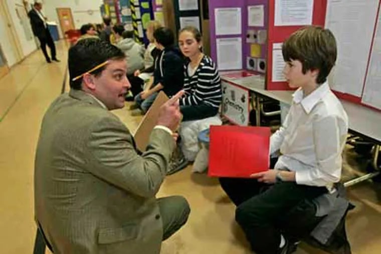 David T. Chew of Pfizer Inc. talks with Justin Torbet, 12, about his science-fair project on the safetyof passwords. Chew was a judge at the event, at East Coventry Elementary School. (Michael Bryant / Staff)
