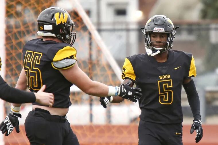 Archbishop Wood running back Nasir Peoples (5) is congratulated by lineman Albert Glasgow (55) after scoring a touchdown in a 36-6 win over Simon Gratz.
