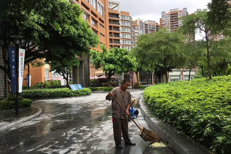 A worker sweeps near the high-rise apartment buildings in the Canton Place where U.S. government workers who experienced unexplained health issues in Guangzhou, China. (AP Photo/Kelvin Chan) 
