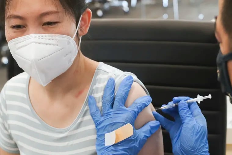Ying Zhang receives her first dose of the COVID-19 vaccine at the Crane Community Center in Philadelphia in July.