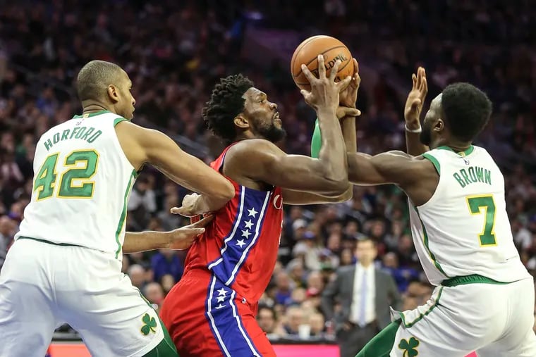 Joel Embiid tangles with the Celtics' Jaylen Brown (right) and Al Horford during the Sixers' loss on Feb. 12.