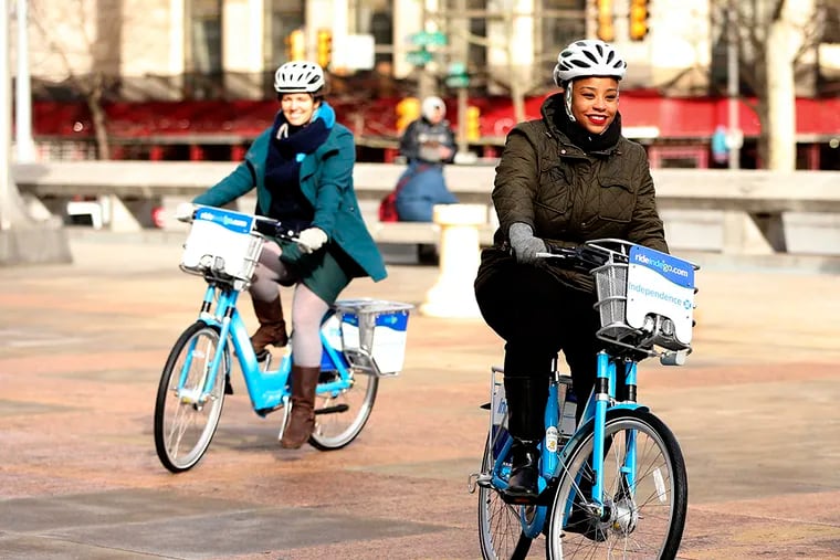 Carniesha Kwashie (right) and Claudia Setubal try out the Indego bicycles.