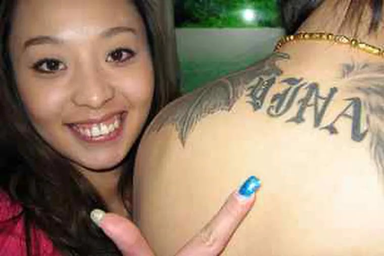Ting Ting shows off the tattoo on the back of her cousin Zhang Hui, who used English lettering to spell out the name of an ex-girlfriend.