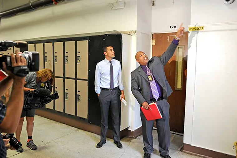 Exeutive director for school safety Anthony Bland (right) demonstrates new security camera installed at Camden High School August 21, 2014. Superintendent Paymon Rouhanifard (rear) looks on following announcement of new measures to ensure Camden students are safe on their journeys to school, and that they arrive ready to learn in secure, motivating school environments. The measures include community involvement and high-tech solutions. ( TOM GRALISH / Staff Photographer )