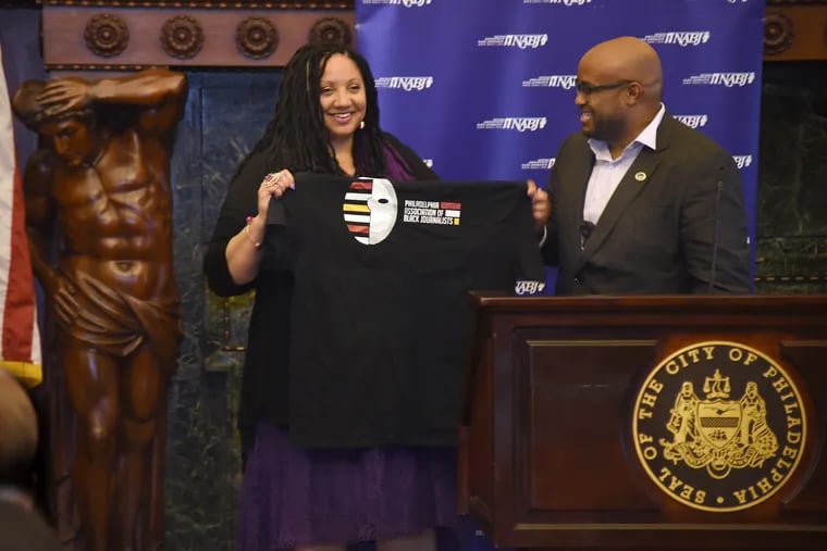 Sarah Glover,  the outgoing president of the National Association of Black Journalists (NABJ), is presented with gifts, including a T-shirt from Manuel Smith, president of the Philadelphia Association of Black Journalists (PABJ), as she is honored at City Hall on Thursday, May 23, 2019.