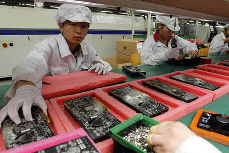 Staff members work on the production line at the Foxconn complex where iPhones and Dell computers are made. The chairman spoke with reporters about the number of suicides.