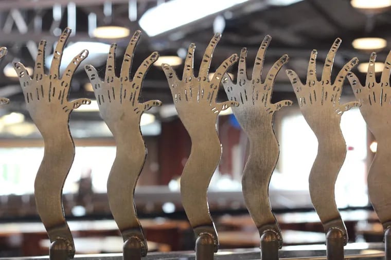 The "Tired Hands" motif is a thing at Fermentaria, in Ardmore. ( Michael Klein / Philly.com )