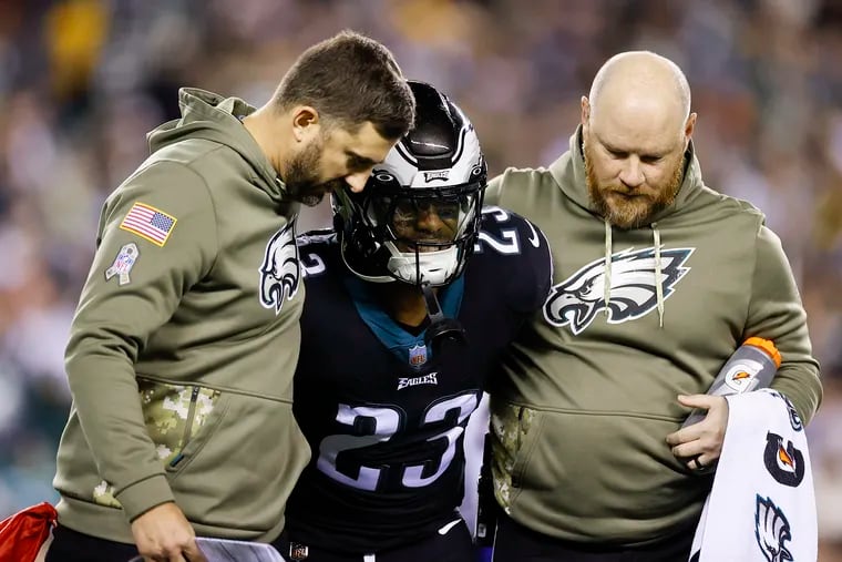 Eagles safety C.J. Gardner-Johnson is helped off the field by coach Nick Sirianni (left) and a member of the athletic training staff on Sunday night.
