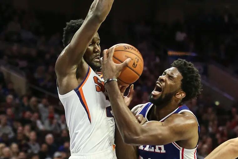 Sixers' Joel Embiid gets fouled by Suns' Deandre Ayton during the 2nd quarter at the Wells Fargo Center in Philadelphia, Monday, November 19, 2018. STEVEN M. FALK / Staff Photographer